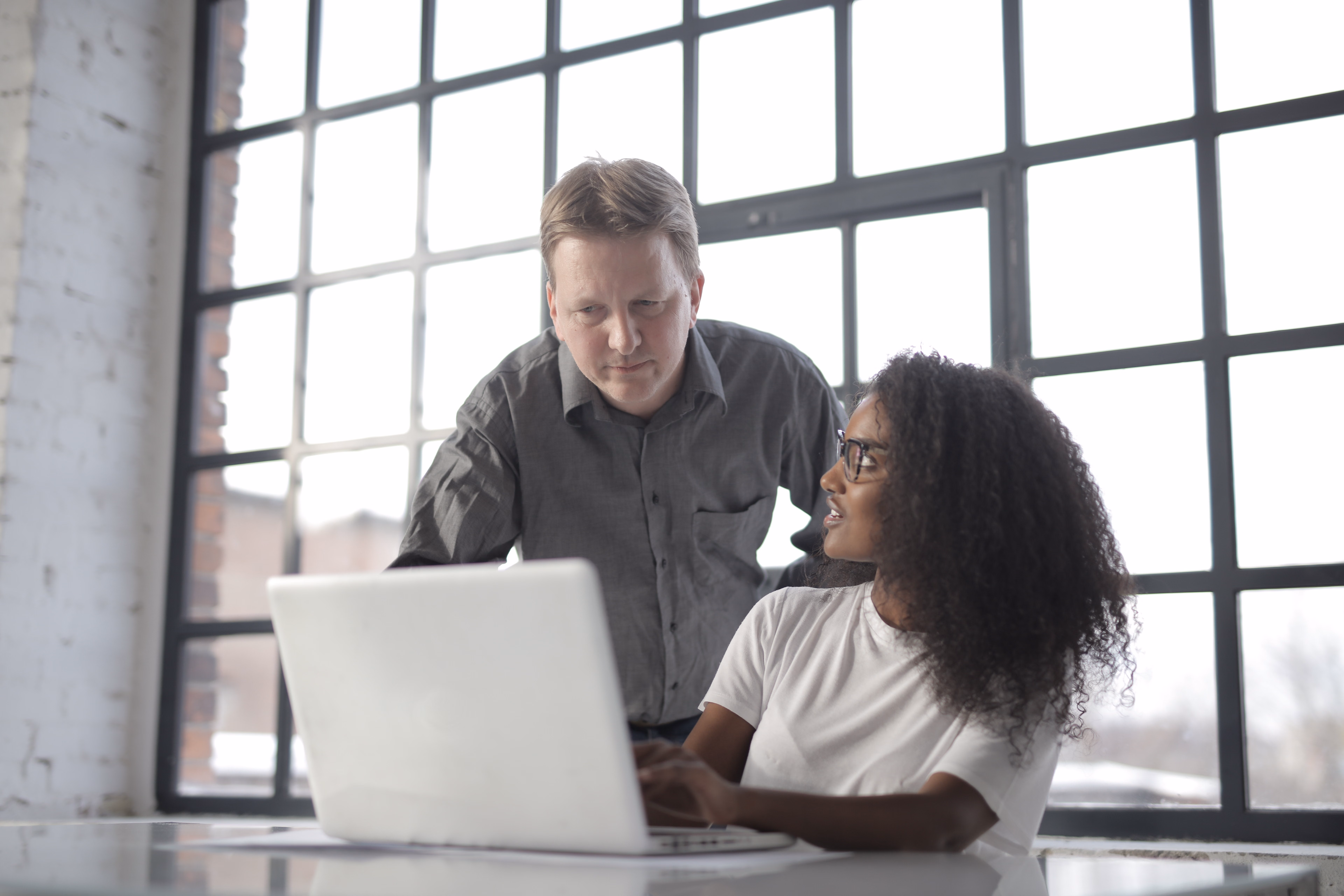 Business professionals collaborating around a laptop